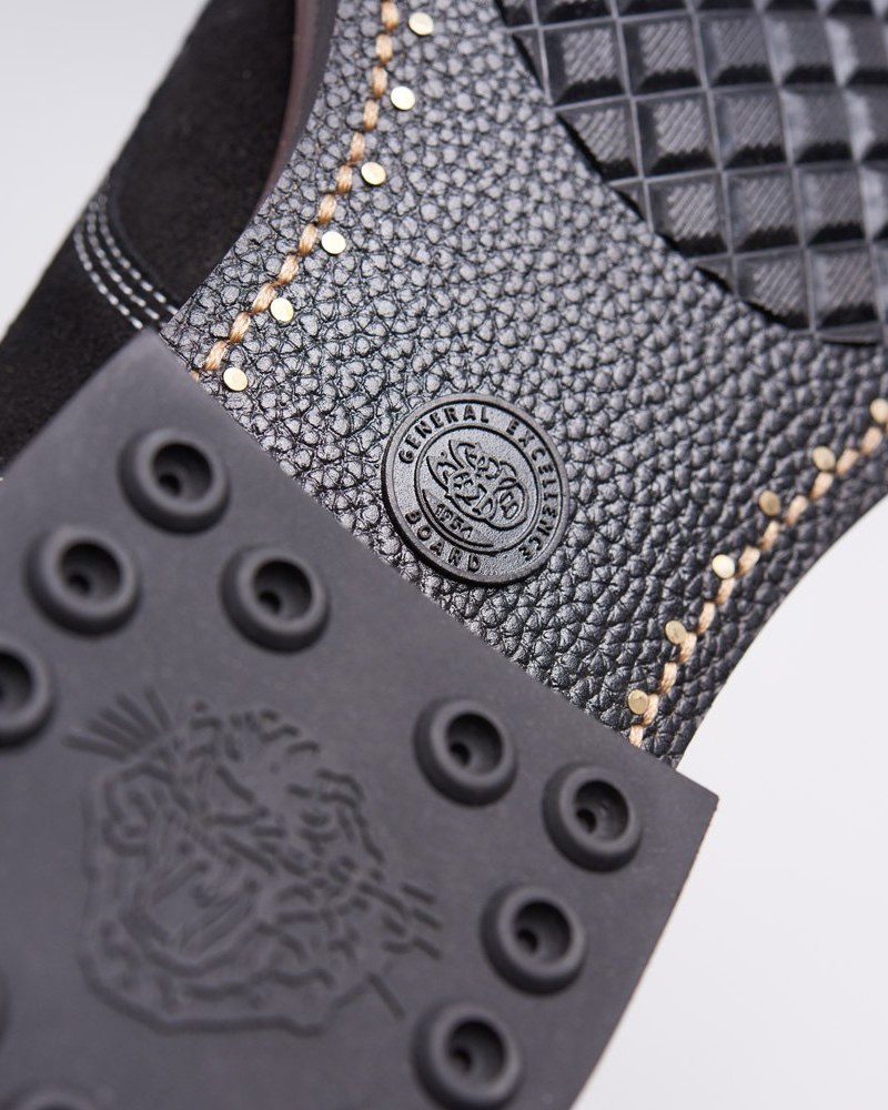 A macro detail of the Officer Boots' refined sole and footbed: a tooled rubber outsole with circular tread, decorative brass studs running along an edge-bound seam, and quilted insole texture above.