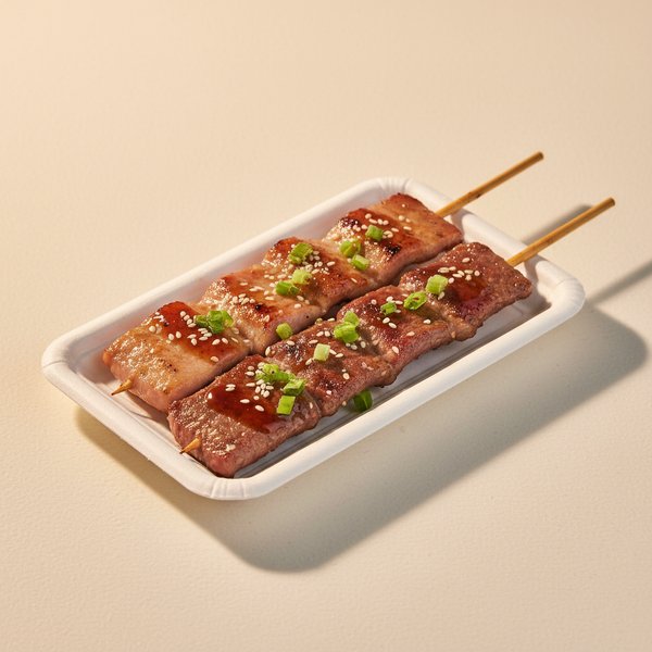 Grilled meat skewers with char marks.