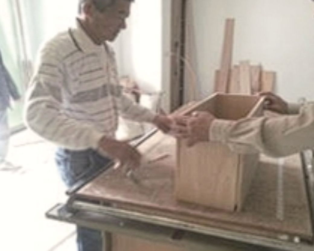 Team examining a wooden mockup of the body, with mentor present.